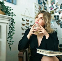 a woman sitting in a chair holding a book